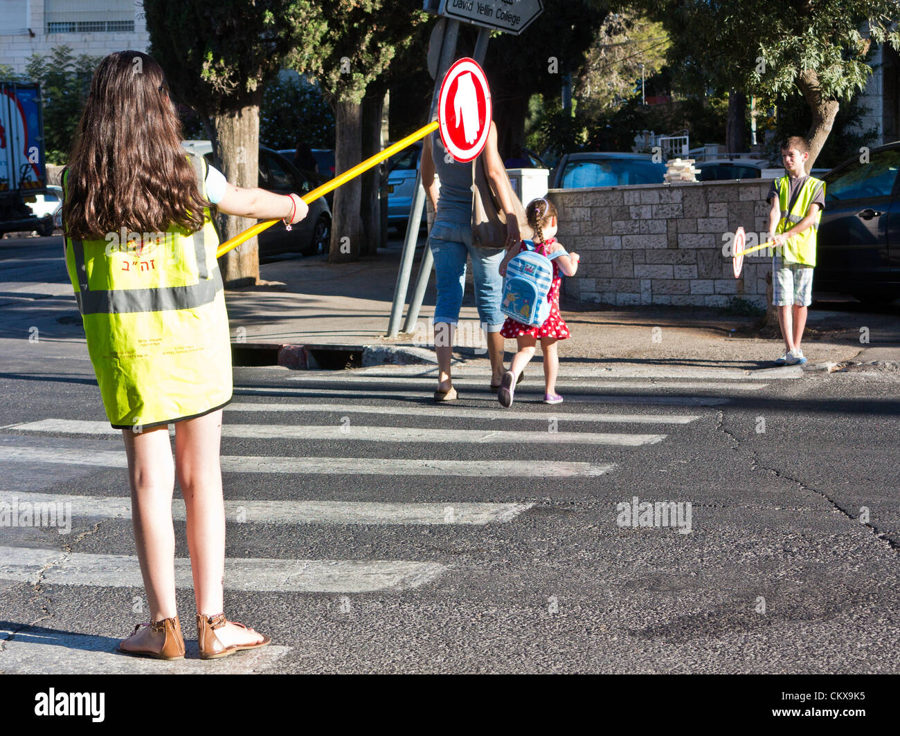 27. August 2012. Die Schüler der sechsten Klasse Leistungen des Verkehrs Überwachung und Unterstützung der jüngeren Schüler in sicheren Zugang auf Bet-Hakerem Grundschule. Jerusalem, Israel. 27. August 2012.   Israelische Kinder gehen wieder zur Schule heute, Abschaffung der traditionellen Sept. 1. Datum, in einer ersten Stufe des Ministeriums für Bildung mit dem Ziel, die Sommerferien 6 Wochen verkürzen eingeleiteten Reformen teilweise entlastet Eltern enorme finanzielle Aufwendungen. Stockfoto