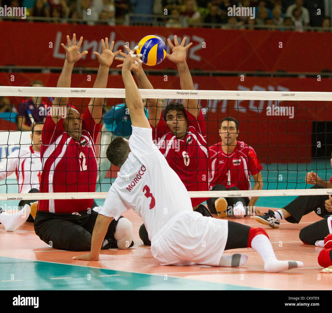 Männer sitzen Volleyball-Spiel zwischen Marokko (weiß) und Ägypten (rot) bei Paralympics London 2012. Stockfoto