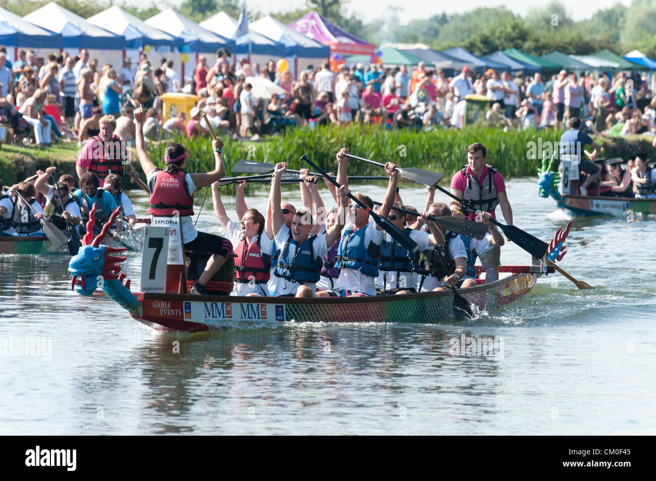 CAmbridge, UK. 8. September 2012. Konkurrenten genießen das Spätsommer-Wetter Cambridge Dragon Boat Festival, auf dem Fluss Cam Fen Ditton Cambridge UK, 8. September 2012.  Rund 50 Teams aus lokalen Organisationen nahmen Teil an den Rennen der 30 Fuß langen chinesischen Drachenbooten um Geld für die East Anglian Kinder Hospize paddeln. Bildnachweis: Julian Eales / Alamy Live News Stockfoto