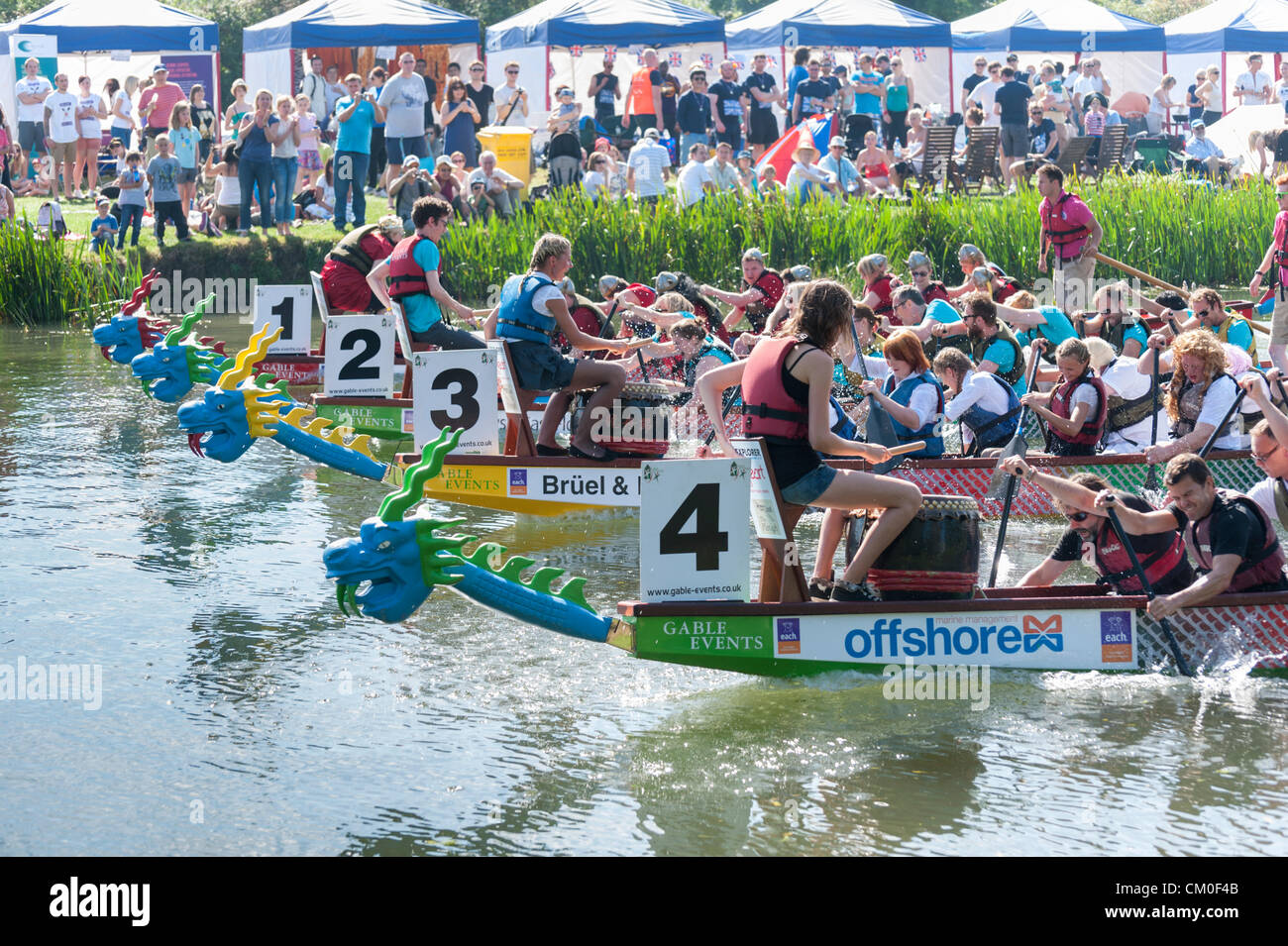 CAmbridge, UK. 8. September 2012. Konkurrenten genießen das Spätsommer-Wetter Cambridge Dragon Boat Festival, auf dem Fluss Cam Fen Ditton Cambridge UK, 8. September 2012.  Rund 50 Teams aus lokalen Organisationen nahmen Teil an den Rennen der 30 Fuß langen chinesischen Drachenbooten um Geld für die East Anglian Kinder Hospize paddeln. Bildnachweis: Julian Eales / Alamy Live News Stockfoto
