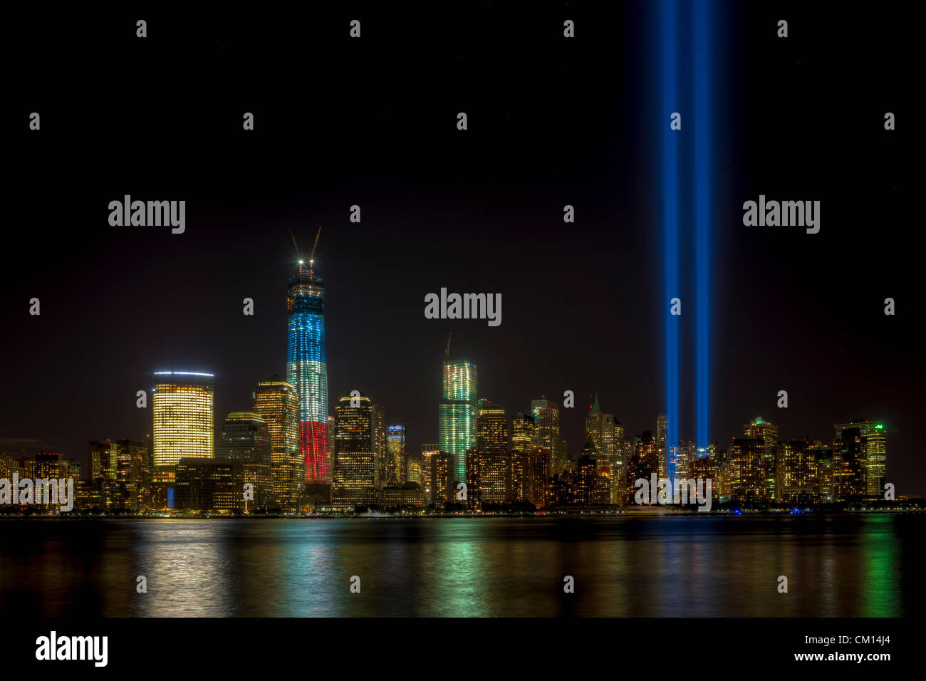 Die zwei Lichtstrahlen der Tribute in Light, eine jährliche Erinnerung an die Ereignisse des 11. September 2001, Leuchten in den Abendhimmel über die Skyline von lower Manhattan in New York City. Stockfoto
