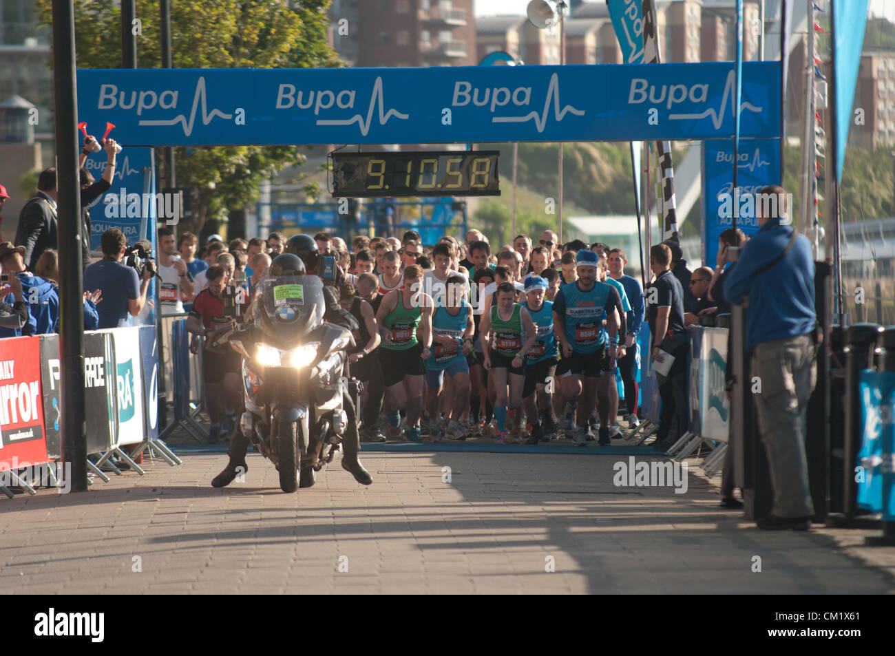 Athleten, die zu Beginn der konstituierenden BUPA Great North 5K bei Newcastle Gateshead Kai warten. Stockfoto