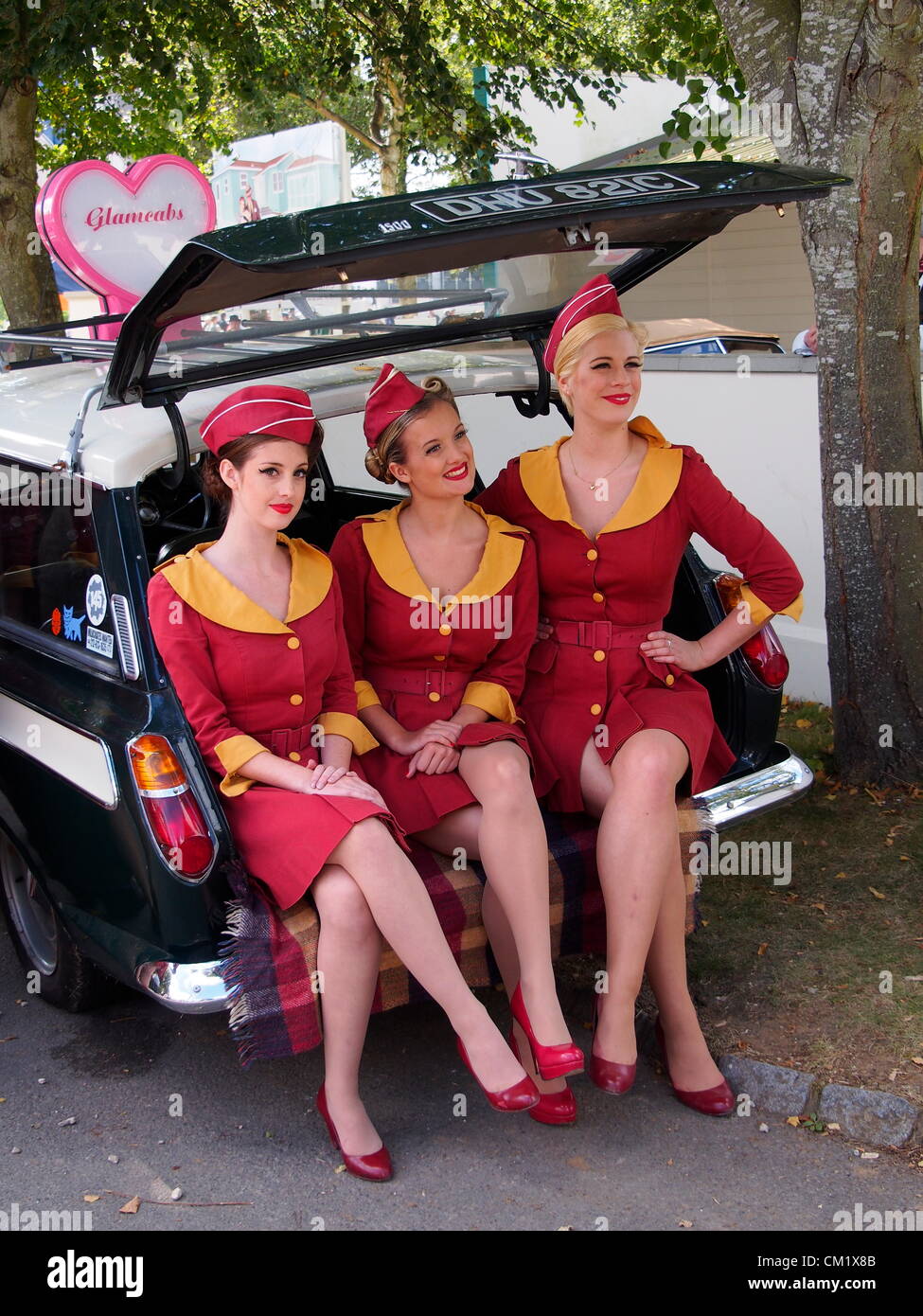 Goodwood Revival Praxis Tag Freitag September 14th.2012. Glamouröse Mädchen im Zeitraum Kleid saß drei nebeneinander auf der Rückseite ein Ford Cortina Estate. Stockfoto