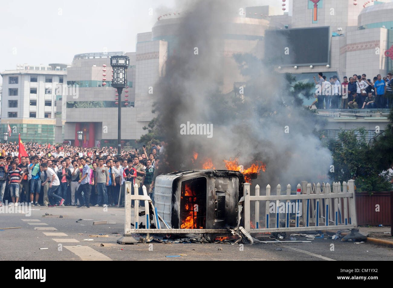 Xian, China. Samstag, 15. September 2012. Anti-japanische Demonstranten verbrennen ein Auto während einer Demonstration im Bell Tower Hotel in Xi ' an, China, auf Samstag, 15. September 2012. Kämpfe brach zwischen Demonstranten und Polizei während eines Marsches von mehr als 10.000 Studenten, die an die Souveränität der Fischerei Islands(Diaoyu Islands) protestierten. Stockfoto