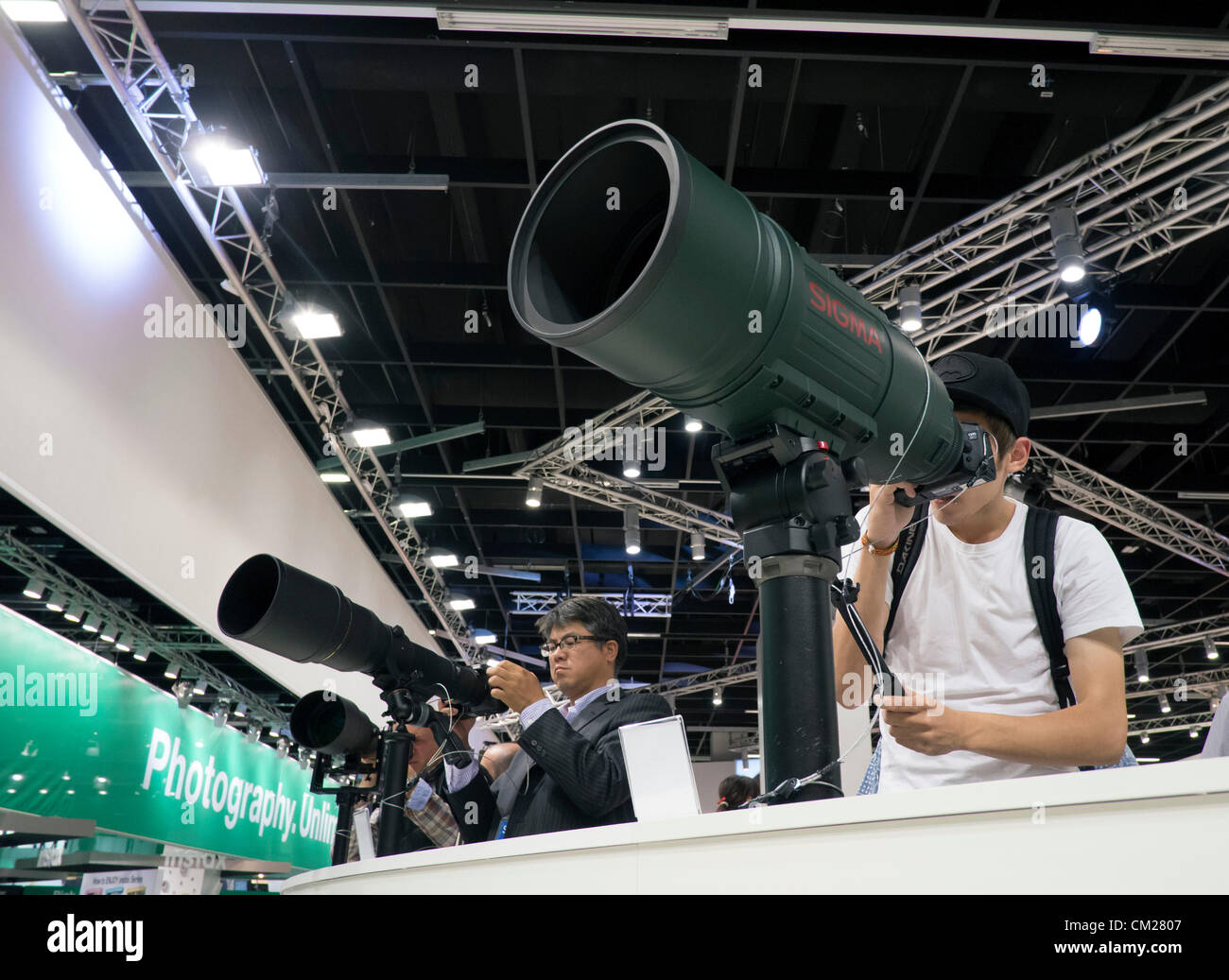 Köln, Deutschland. Besucher zu Sigma stehen ausprobieren sehr große Teleobjektive am Eröffnungstag der halbjährlich stattfindenden Photokina Fotografie und imaging-Messe in Köln statt Stockfoto
