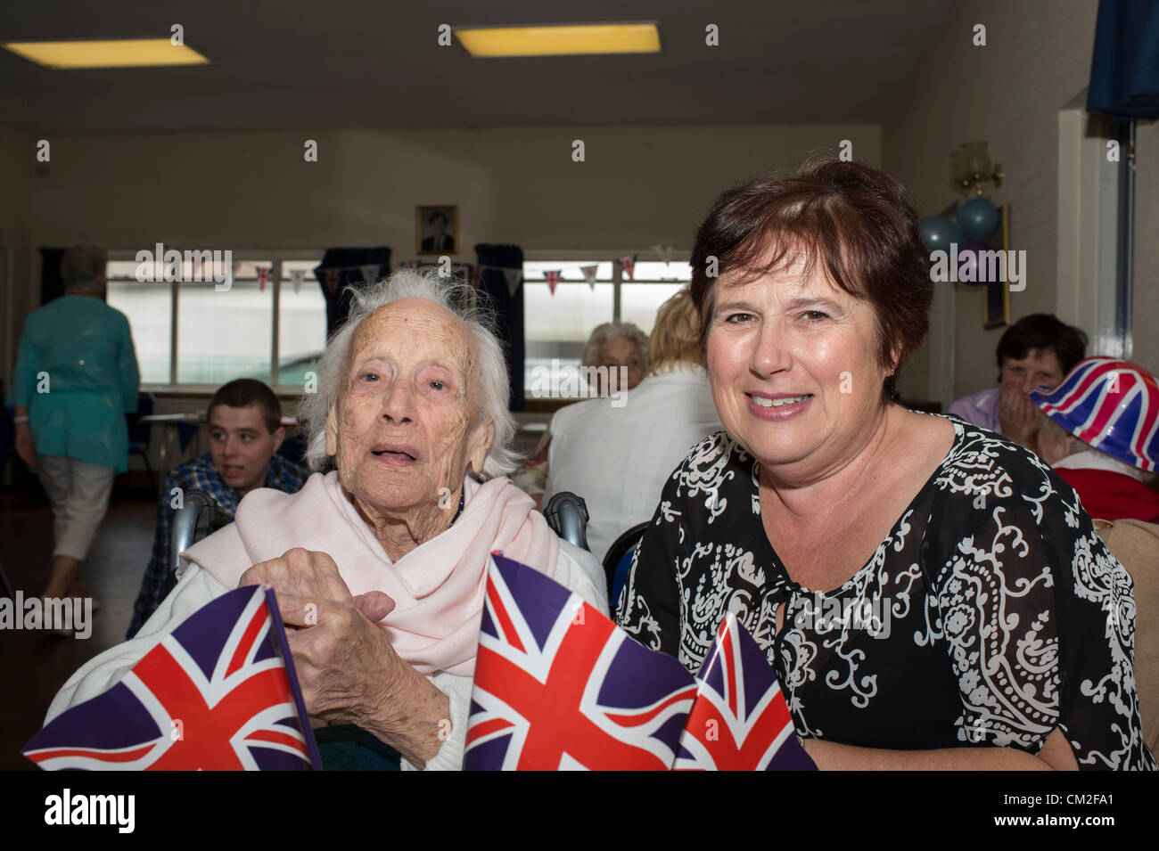 20. September 2012. Leigh on Sea, Essex, England. Die sechsten jährlichen Centenarian Tea Party organisiert von Southend konservative Wartungstafel, David Amess. 14 hundertjährigen besuchte die Conservative Club am Leigh für eine Tee-Party. 2009 sah 29 teilnehmen, die ihren Datensatz so weit ist.  Essie Glauda, 103 Jahre alt, genießt einen Song mit ihrer Tochter. Stockfoto