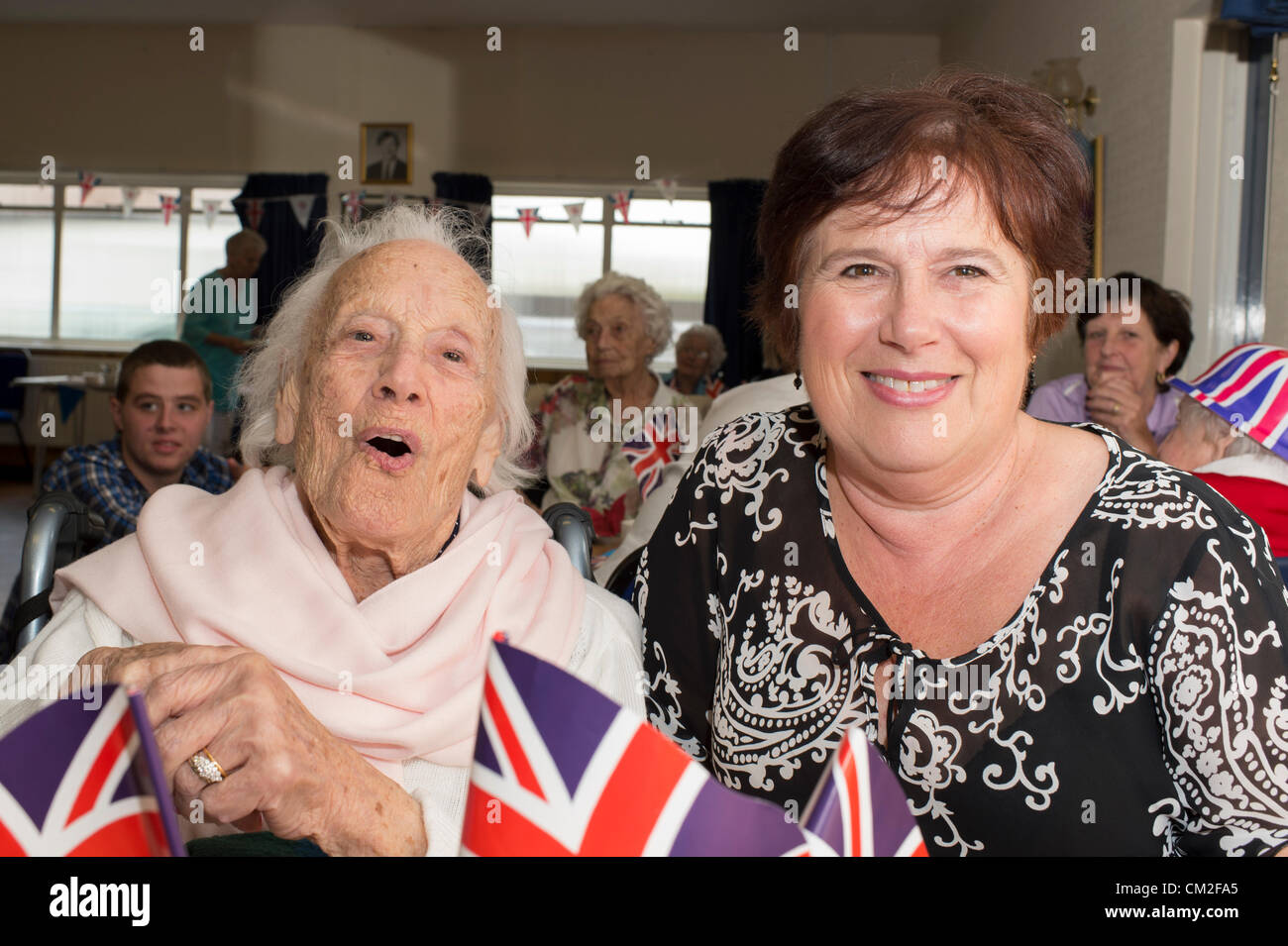 20. September 2012. Leigh on Sea, Essex, England. Die sechsten jährlichen Centenarian Tea Party organisiert von Southend konservative Wartungstafel, David Amess. 14 hundertjährigen besuchte die Conservative Club am Leigh für eine Tee-Party. 2009 sah 29 teilnehmen, die ihren Datensatz so weit ist. Essie Glauda, 103 Jahre alt, genießt einen Song mit ihrer Tochter. Stockfoto