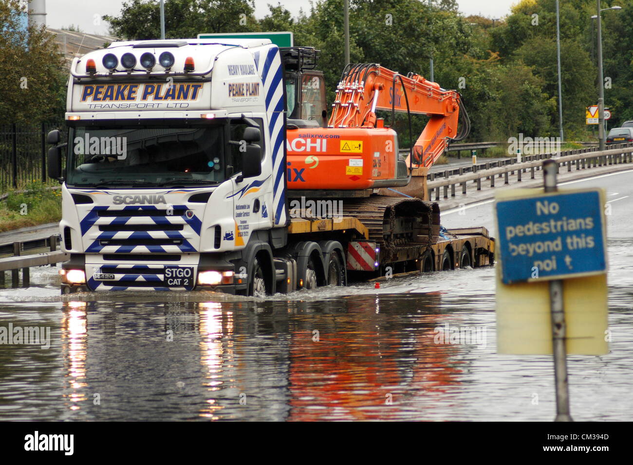 24. September 2012. LKW mit Bagger fährt durch überflutete A617 - A61 Hörner Brücke Kreisverkehr, Chesterfield, Derbyshire, UK. Stockfoto
