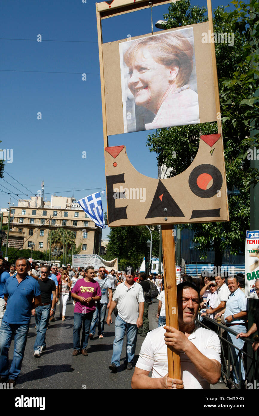 26.09.2012 Athen Griechenland. Demonstranten halten eine Guillotine mit Foto von Angela Merkel. Griechische Arbeitnehmer ging außerhalb des Arbeitsplatzes Mittwoch für den ersten Generalstreik seit Koalition-Regierung des Landes im Juni, wie der Ministerpräsident und Finanzminister ein Paket von Euro 11,5 Milliarden gehämmert ($ 14,87 Milliarden) in Ausgabenkürzungen. Athen hat gekämpft, um mit mehr strafenden Sparmaßnahmen kommen, das wäre akzeptabel, seine Rettung Gläubiger mit Meinungsverschiedenheiten zwischen den drei Parteien, aus denen sich die Regierungskoalition. Stockfoto