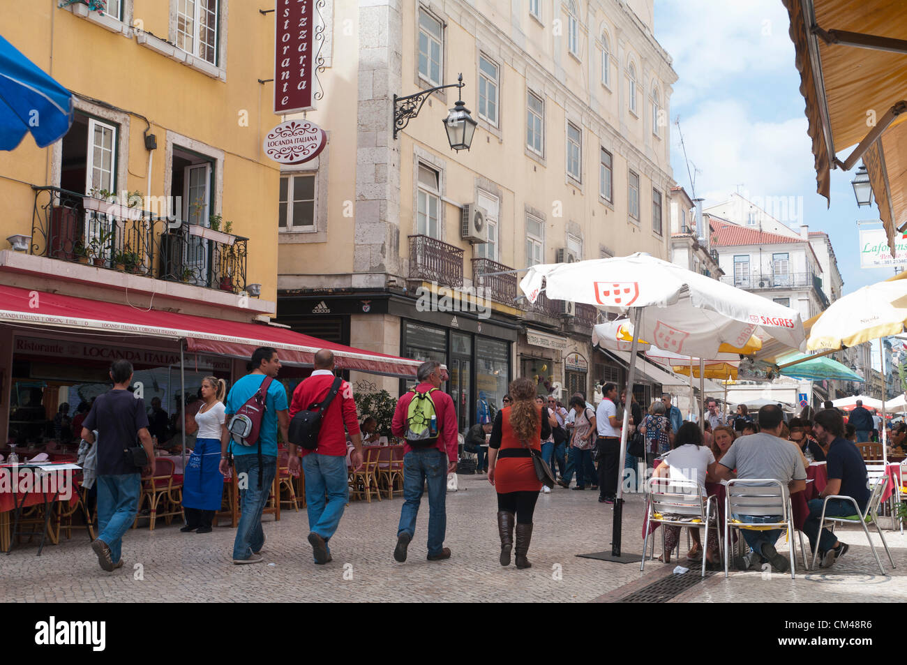 Touristen schlendern an Cafés und historischen Gebäuden in der Innenstadt von Lissabon vorbei und genießen die Cafés im Freien und das pulsierende Straßenleben im Baixa-CH Stockfoto