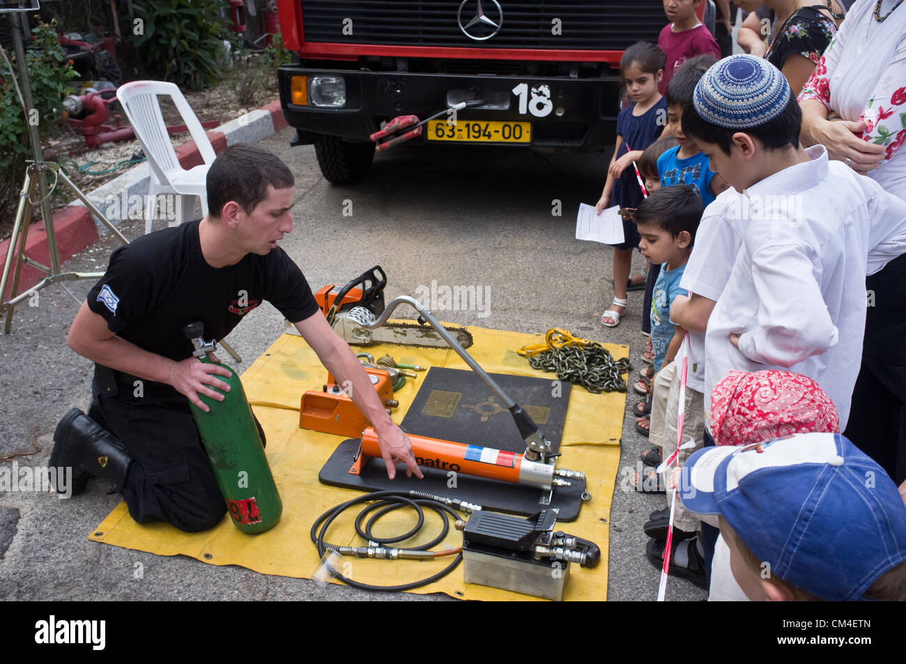 Jerusalem, Israel. 2. Oktober 2012. Kinder genießen die Möglichkeit, Feuerwehrautos einsteigen und sehen Feuerlöschgeräte aus der Nähe an der Givat Mordechai Station wie Jerusalem Feuerwehr seine Türen für die Öffentlichkeit öffnet.  Jerusalem, Israel. 2. Oktober 2012.  Jerusalem-Feuerwehr öffnet seine Türen für die Öffentlichkeit in Givat Mordechai Station ermöglicht der Öffentlichkeit, die Arbeit der Feuerwehrleute aus nächster Nähe zu sehen. Die Jerusalem-Feuerwehr entspricht jährlich mehr als 8.000 Veranstaltungen. Stockfoto