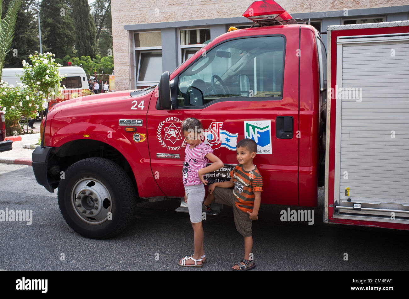 Jerusalem, Israel. 2. Oktober 2012. Kinder genießen die Möglichkeit, Feuerwehrautos einsteigen und sehen Feuerlöschgeräte aus der Nähe an der Givat Mordechai Station wie Jerusalem Feuerwehr seine Türen für die Öffentlichkeit öffnet.  Jerusalem, Israel. 2. Oktober 2012.  Jerusalem-Feuerwehr öffnet seine Türen für die Öffentlichkeit in Givat Mordechai Station ermöglicht der Öffentlichkeit, die Arbeit der Feuerwehrleute aus nächster Nähe zu sehen. Die Jerusalem-Feuerwehr entspricht jährlich mehr als 8.000 Veranstaltungen. Stockfoto