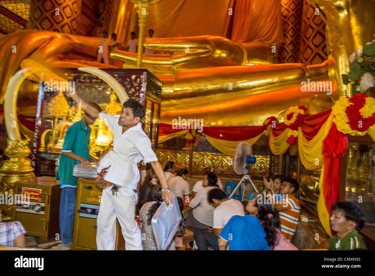 3. Oktober 2012 - Thailand - wirft eine Begleitperson eine Safranrobe verwendet, während ein Verdienst machen Zeremonie im Wat Phananchoeng in Ayutthaya Buddha bis zu der Statue zu kleiden. Der Tempel ist Heimat der größten vergoldete Buddha-Statue in Thailand. Der Tempel wurde gebaut, bevor die Stadt Ayutthaya gegründet wurde. Ayutthaya ist die ehemalige kaiserliche Hauptstadt der damaligen Siam, heute Thailand. Ayutthaya wurde wurde um 1350 gegründet und der zweite Hauptstadt von Siam nach Sukhothai. Ayutthaya Lage zwischen China, Indien und dem Malaiischen Archipel gemacht Ayutthaya Handelszentrum der das Seengebiet. Von 1700 Ayutthaya w Stockfoto