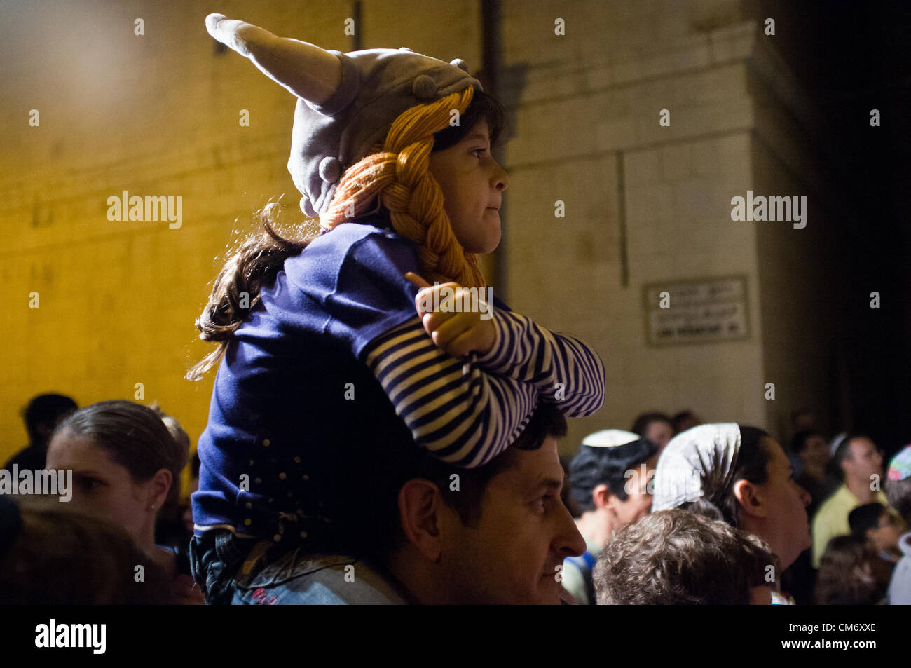 Ein junges Mädchen auf Vaters Schultern Uhren eine Leistung in einem der Christian Quarter Gassen an die Ritter von der Nacht-Festival. Jerusalem, Israel. 18. Oktober 2012.  Dritte jährliche Altstadtfest Ritter eröffnet und hat eine Laufzeit von vier aufeinanderfolgenden Donnerstagen. Das diesjährige Thema Ritter und Drachen und Funktionen Schlachtszenen zwischen Ritter und Feuer spucken Drachen, Prinzessinnen und Gauklern. Stockfoto