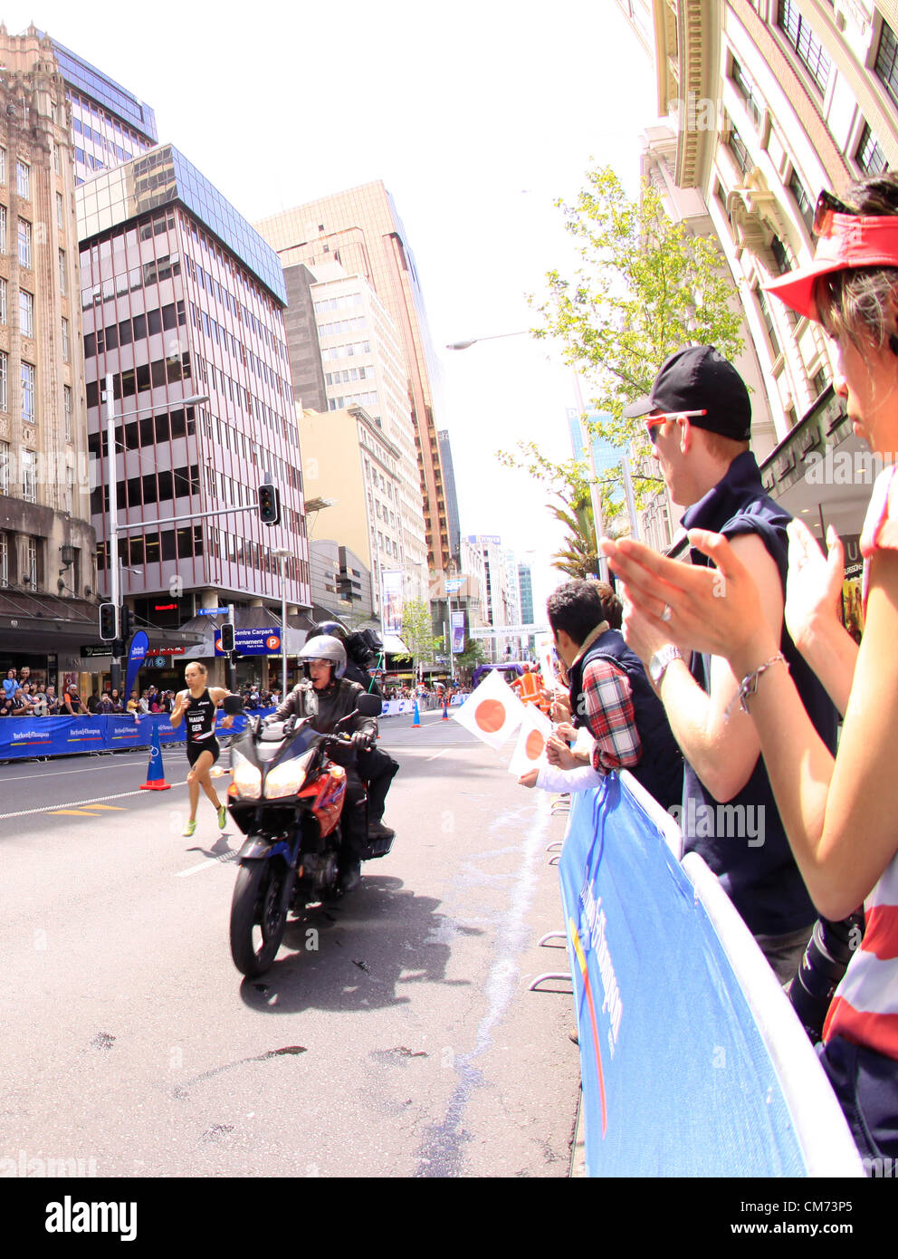 AUCKLAND, Neuseeland-Okt. 20,2012: TeilnehmerInnen in ITU Triathlon Grand Finale Weltmeisterschaft führen in die letzte Etappe die Hauptstraße der Innenstadt von Auckland. Stockfoto