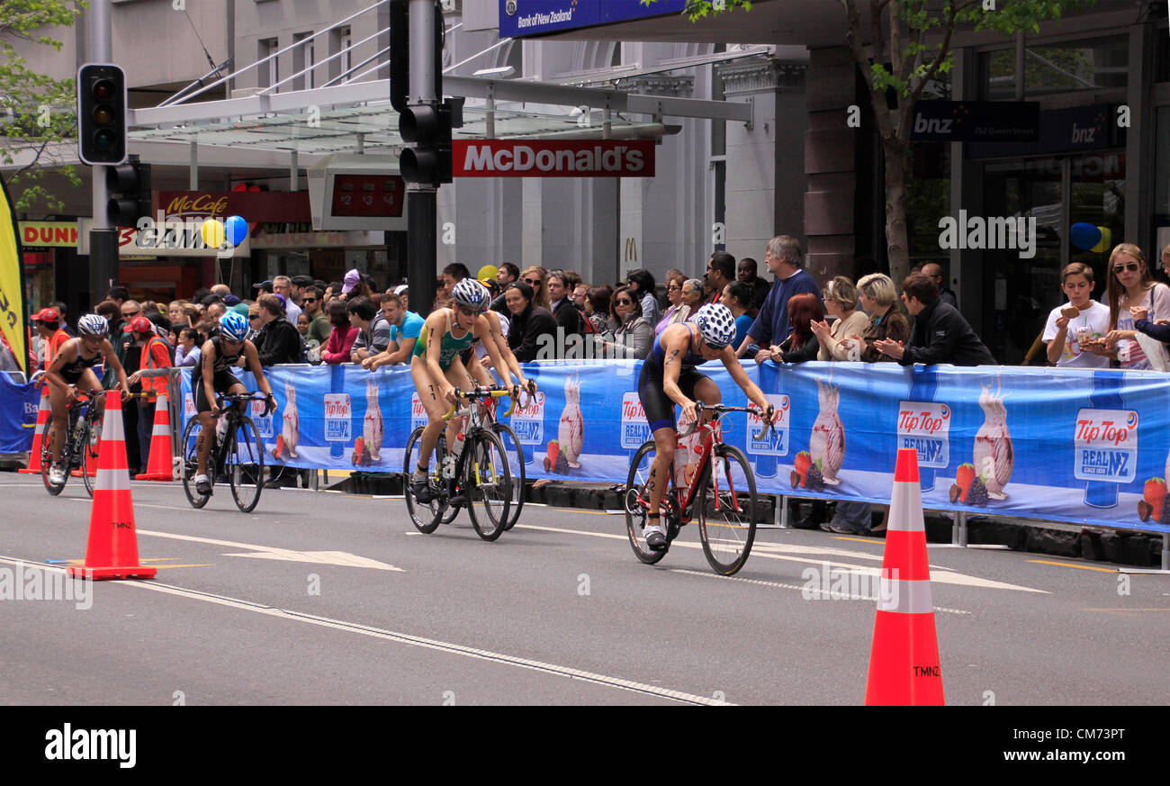 AUCKLAND, Neuseeland-Okt. 20,2012: TeilnehmerInnen in ITU Triathlon Grand Finale Weltmeisterschaft führen in die letzte Etappe die Hauptstraße der Innenstadt von Auckland. Stockfoto