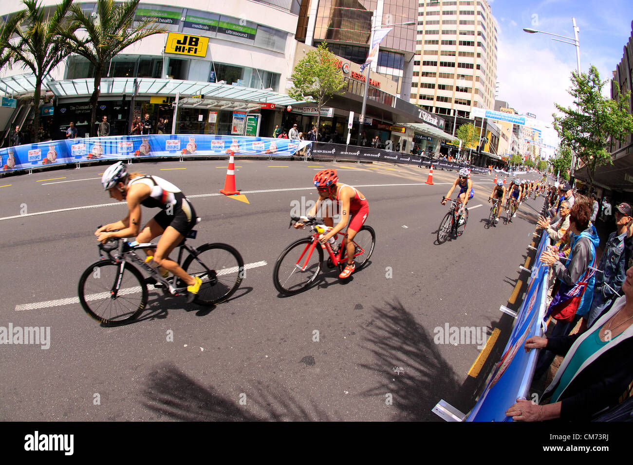 AUCKLAND, Neuseeland-Okt. 20,2012: TeilnehmerInnen in ITU Triathlon Grand Finale Weltmeisterschaft fahren die Hauptstraße der Innenstadt von Auckland. Stockfoto