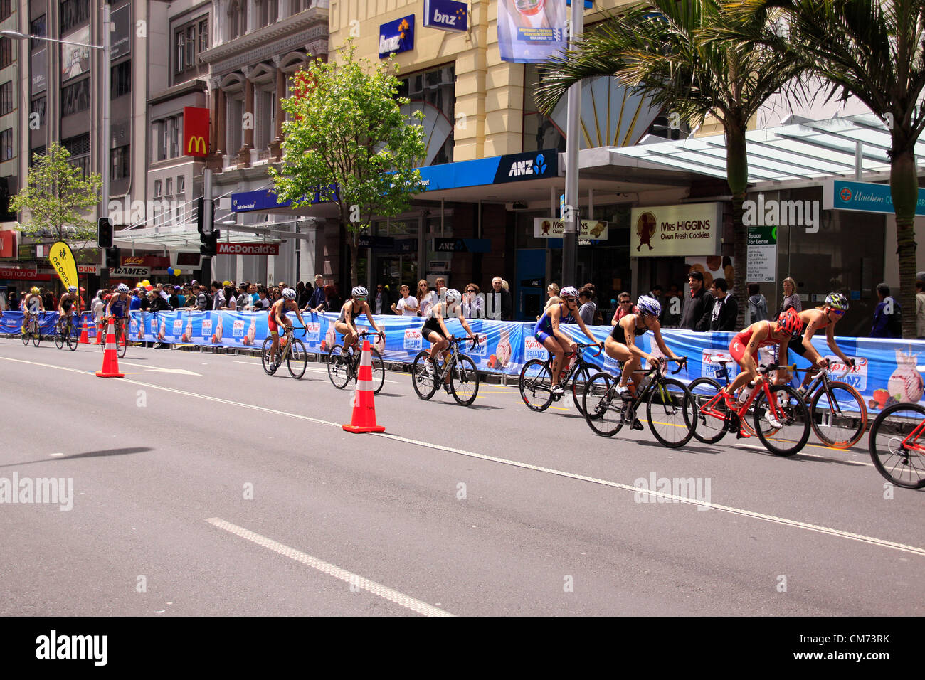 AUCKLAND, Neuseeland-Okt. 20,2012: TeilnehmerInnen in ITU Triathlon Grand Finale Weltmeisterschaft führen in die letzte Etappe die Hauptstraße der Innenstadt von Auckland. Stockfoto