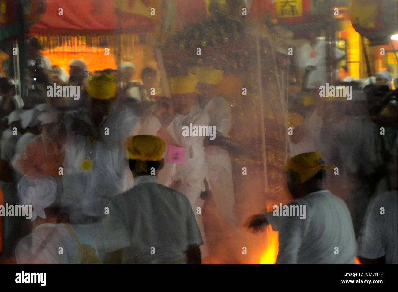 Malaysischen Chinesen ethnischen Spaziergang auf brennende Kohle während des Tragens ein neun Kaiser am letzten Tag des Festivals neun Kaiser Götter in Kuala Lumpur, Malaysia, spät 23. Oktober 2012. Stockfoto