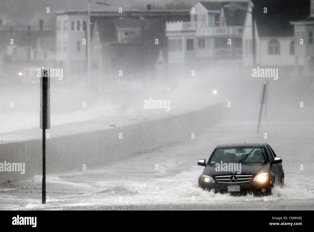 Winthrop, Massachusetts, USA. Ein Auto fährt durch Hochwasser, wie die Auswirkungen von starkem Wind und Wellen von Hurrikan Sandy in Winthrop, Massachusetts, Montag, 29. Oktober 2012 spürbar sind. Das große Wettersystem wird voraussichtlich Landfall in südlichem New Jersey späten Montag machen und Wetter entlang der Ostküste der Vereinigten Staaten betrifft. Stockfoto