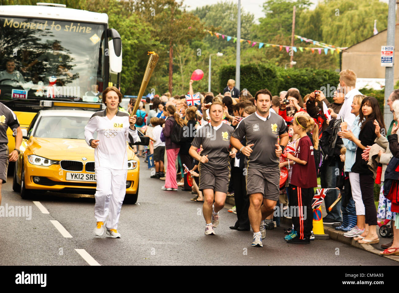 Claire Chappill, von Scunthorpe, trägt die Olympische Fackel während des Olympischen Fackellaufs auf der Strecke durch Saxilby, Lincoln, Lincolnshire, UK am 28. Juni 2012, in der Coutdown zu den Olympischen Spielen. Stockfoto