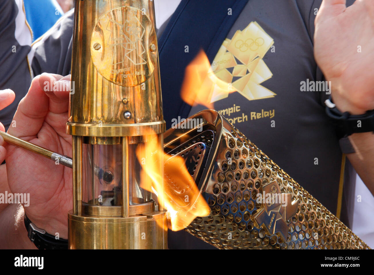 Derbyshire, UK. Freitag, 29. Juni 2012. Das Olympische Feuer vorbei von Fackel, Laterne, bewacht von Met. Polizei Taschenlampe Sicherheitsteam Chatsworth House. Stockfoto