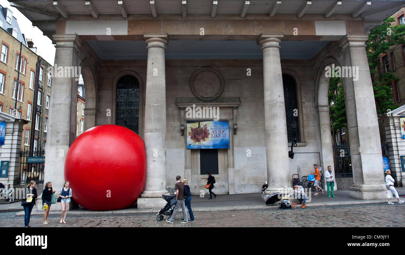 Covent Garden, London, UK. Freitag, 29. Juni 2012. Die Big Red Ball Project kommt eingekeilt zwischen zwei Säulen. In den letzten drei Tagen zeigte es sich bei den Golden Jubilee Bridge, Waterloo Bridge und jetzt Covent Garden. Der Künstler Kurt Perschke, ist das Vereinigte Königreich mit dem Projekt aus dem Südwesten in Richtung London gereist. Es wurde zuvor in Sydney, Taipei und Barcelona beobachtet. Morgen geht es auf der Londoner Southbank irgendwo. Stockfoto