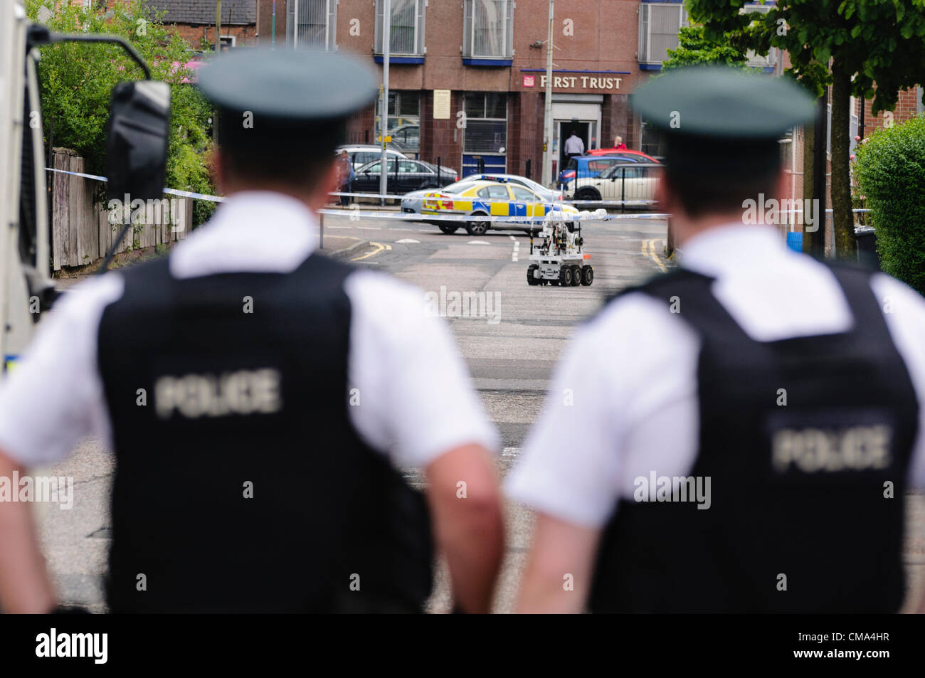 Belfast 07.02.2012 Belfast - Polizisten beobachten einen Armee Roboter zur Bombenräumung ein verdächtiges Gerät untersuchen Stockfoto