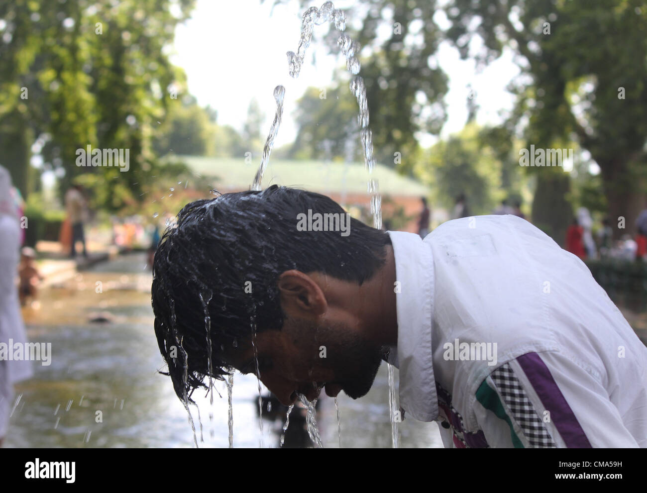 Ein Kashmiri Muslim halten Kopf mit Brunnen während heißer Tag in Srinagar, der Sommer-Capiatl des indischen Kaschmir auf 1,7,2012 Foto/Altaf Zargar/Zuma Press Stockfoto
