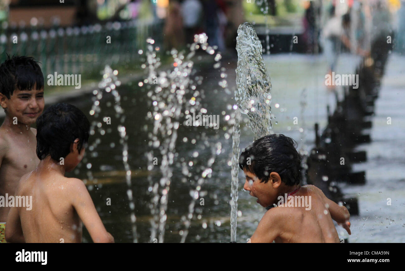 Kashmiri muslimische Kinder spielen mit Brunnen während heißer Tag in Srinagar, der Sommer-Capiatl des indischen Kaschmir auf 1,7,2012 Foto/Altaf Zargar/Zuma Press Stockfoto