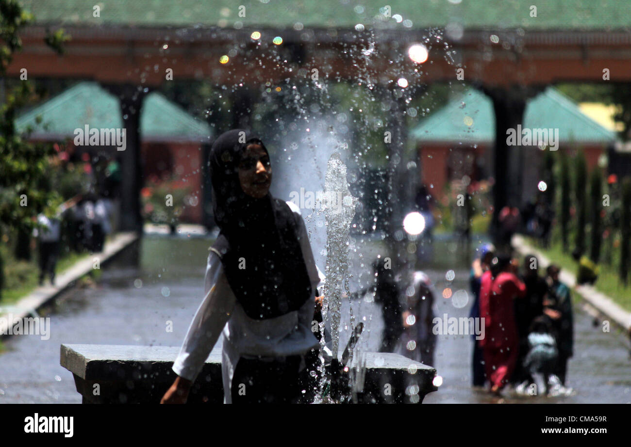 Kashmiri muslimisches Mädchen spielen mit Brunnen während heißen Tag in Srinagar, der Sommer-Capiatl des indischen Kaschmir auf 1,7,2012 Foto/Altaf Zargar/Zuma Press Stockfoto