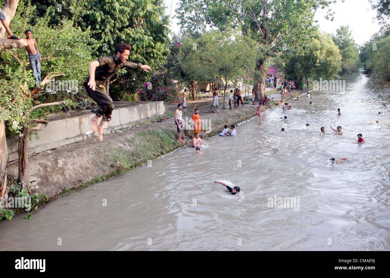 Menschen Baden, die Hitze an einem Kanal, an einem heißen Tag der Sommersaison in Lahore am Mittwoch, 4. Juli 2012 zu schlagen. Stockfoto