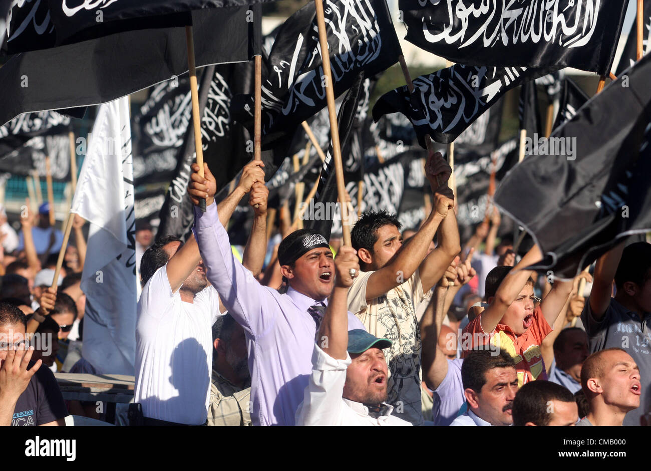 8. Juli 2012 - Ramallah, Westjordanland, Palästinensische Autonomiegebiete - palästinensischen Unterstützer von Hizb-Ut-Tahrir oder die islamische Befreiung-Partei, skandieren Parolen und schwarzen und weiße Fahnen mit den religiösen Welle schreiben "Es gibt keinen Gott außer Gott und Mohammed ist sein Prophet'' während einer Kundgebung in der Westbank Ramallah am 7. Juli 2012. Die islamischen Befreiung-Partei, die für die Rückkehr des islamischen Kalifats und die Errichtung einer islamischen Staaten aufruft, hat keine militärischen Macht in den palästinensischen Gebieten und ihr Ziel ist, alle muslimischen Länder unter einer Nation beizutreten (Credit-Bild: © Issam Rimawi Stockfoto