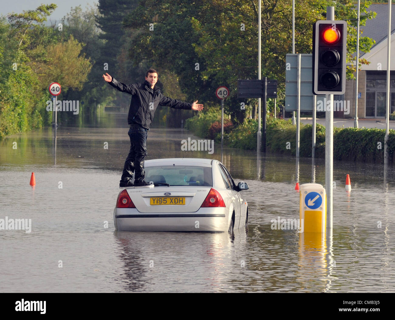 Dorset, UK. 8. Juli 2012.One junger Fahrer erwischt von den Überschwemmungen im Zentrum Stadt in Weymouth. Stockfoto