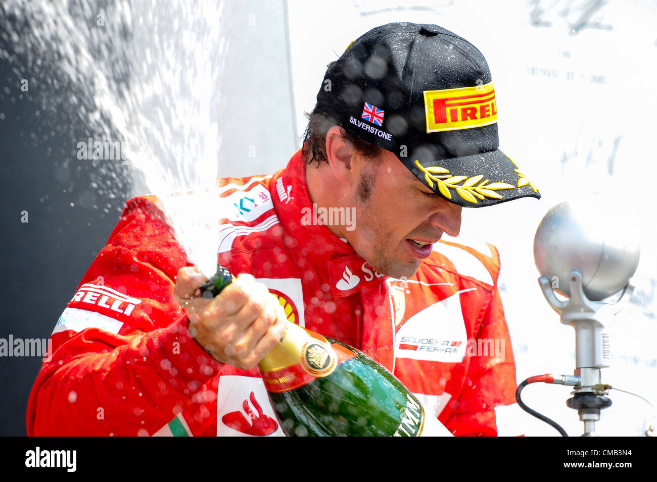 08.07.2012 Towcester, England. Runner-up Fernando Alonso Spanien und Scuderia Ferrari sprüht Champagner auf dem Podium nach dem Rennen beim britischen Grand Prix Santander, Runde 9 der 2012 FIA Formel 1 Weltmeisterschaft in Silverstone. Stockfoto