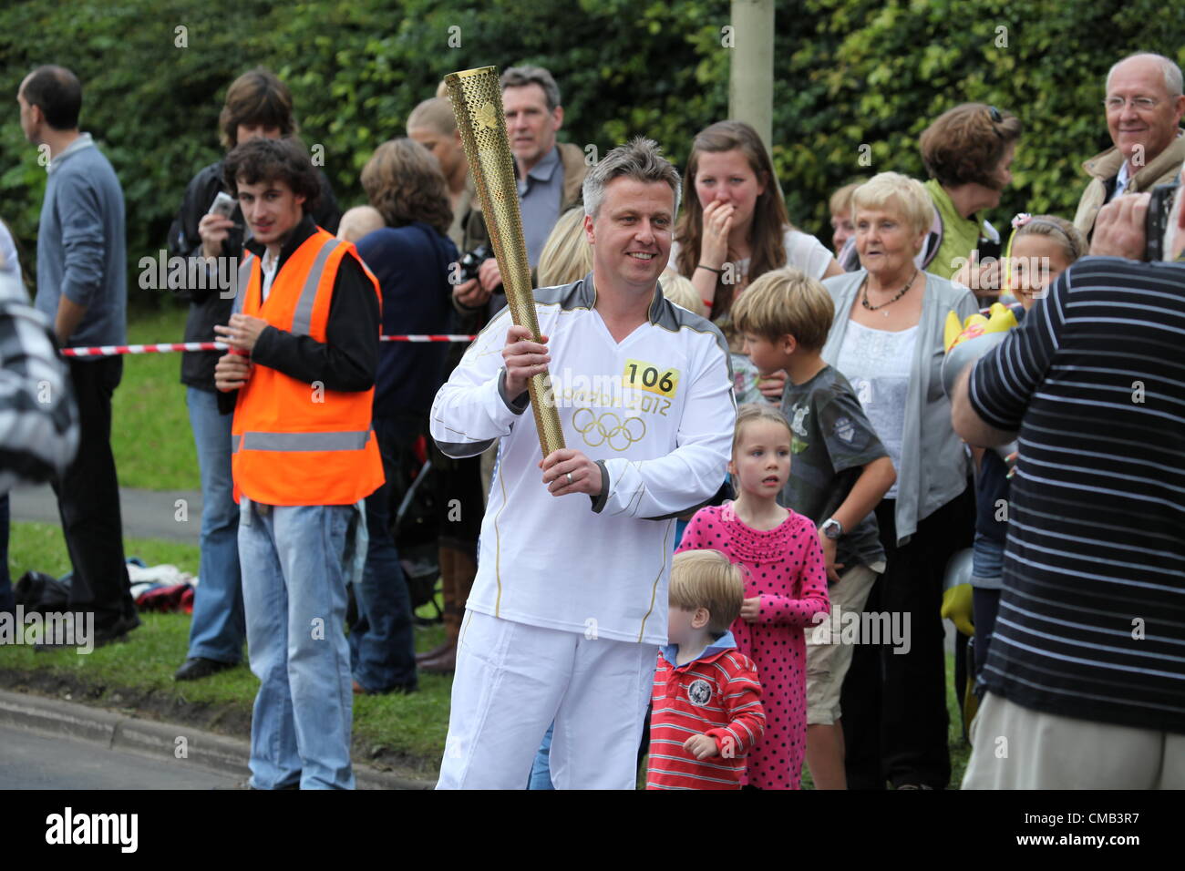 Hemel Hempstead, Großbritannien. 8. Juli 2012. Fackel-Träger 106 posiert für Fotos am Tag 50 des Olympischen Fackellaufs in Hemel Hempstead Stockfoto