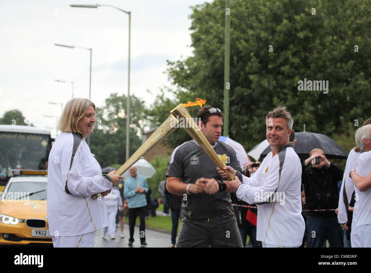 Hemel Hempstead, Großbritannien. 8. Juli 2012. Die Flamme wird von einer Fackel zur anderen am 50. Tag des Olympischen Fackellaufs in Hemel Hempstead übertragen Stockfoto
