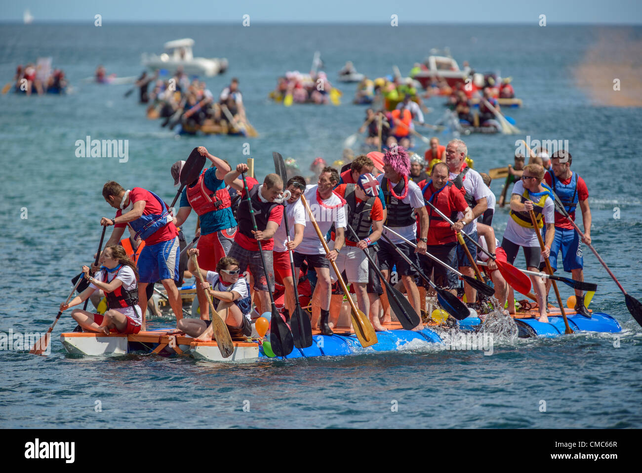 Looe, Cornwall, UK. 15. Juli 2012. Das große Looe Floß Rennen. sah eine Stoßstange Menge entpuppen sich sehen, die Spaß mit vielen Besatzungen paddeln für Nächstenliebe und das schöne Wetter dazu beitragen, es ist ein toller Tagesausflug. Bild von Sean Hernon © Stockfoto