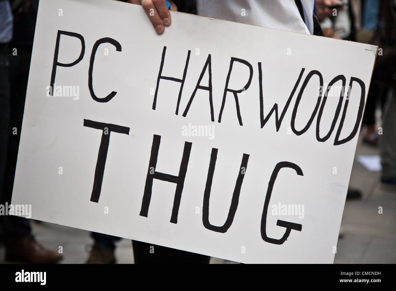 London, UK. 19. Juli 2012 Schild mit der Aufschrift "PC Harwood Thug" Besitz eines Demonstranten, die außen Scotland Yard in Westminster versammelt hatten. Demonstranten versammelten sich dort um eine Demonstration gegen PC Simon Harwood halten Freispruch in Ian Tomlinson Studie. Stockfoto