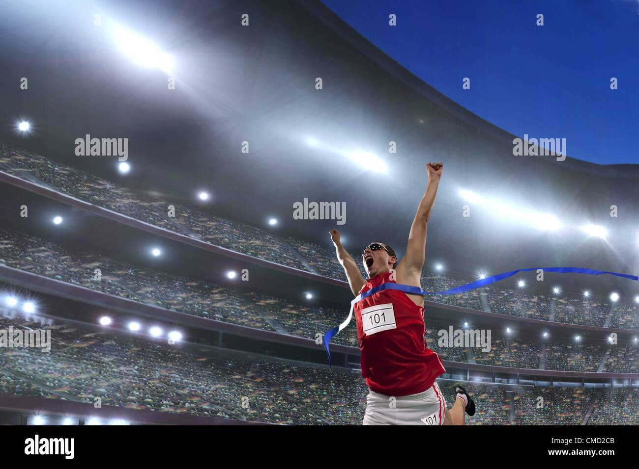 08.11.2011. Modell veröffentlicht Bild eines männlichen Athleten feiert seinen Sieg in ein Leichtathletikstadion vor einer großen Schar von fans Stockfoto