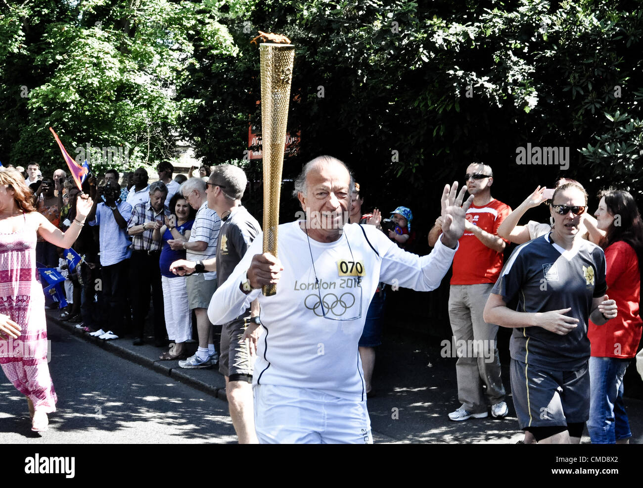 23.07.12 LONDON, UK: Alain Maquet läuft mit der Olympischen Fackel auf Church Road, Croydon. Stockfoto