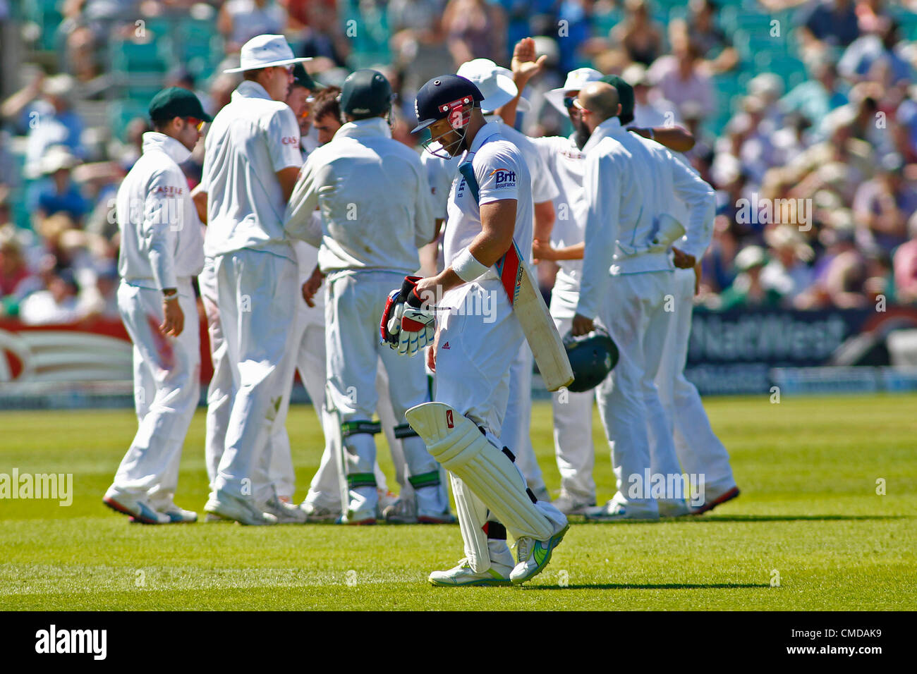 23.07.2012-London, England. Englands Matt Prior geht Weg vorbei an der feiernden südafrikanische Mannschaft während der Investec Cricket Test-Länderspiel zwischen England und Südafrika, spielte auf dem Kia Oval Cricket Ground. Stockfoto
