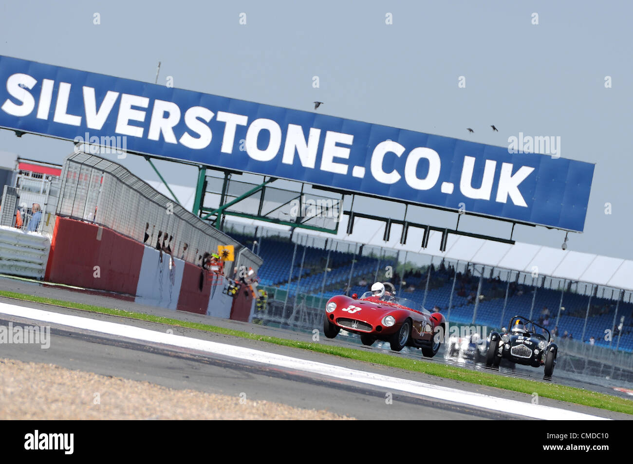 22. Juli 2012, Silverstone im Vereinigten Königreich.  Conrad Ulrich und Willie Green Maserati 300 s Köpfe hinter den nationalen Gruben während der Woodcote Trophy für Pre 56 Sportwagen-Rennen in Silverstone Classic 2012 Stockfoto