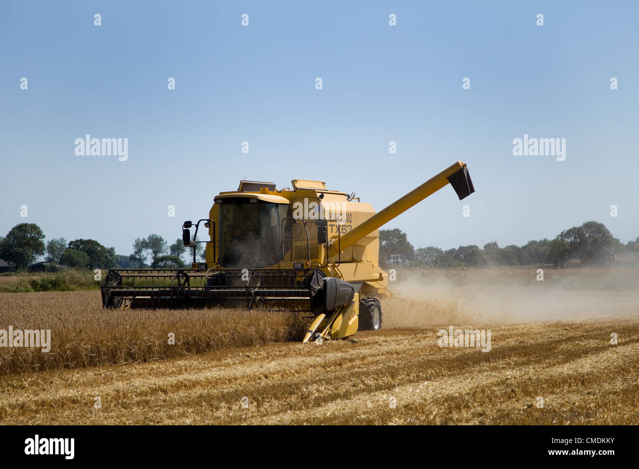 New Holland TX63 Mähdrescher Kämmen Gerste in Norfolk, England gegen einen blauen Sommerhimmel Stockfoto
