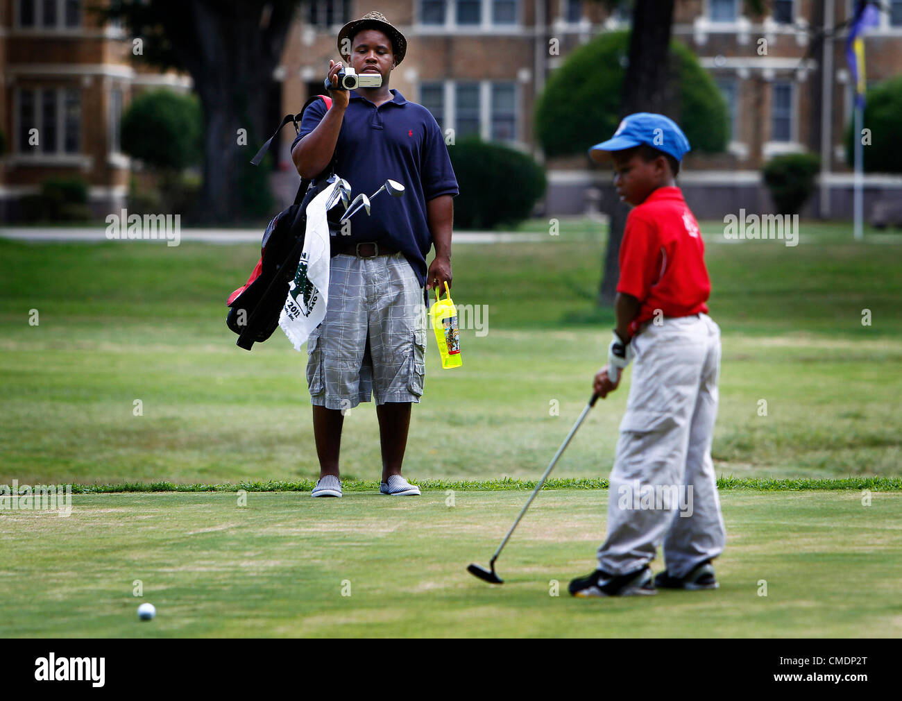 25. Juli 2012 - Memphis, TN, USA - 25. Juli 2012 - Jeremy Johnson (links) Videos seinen Sohn Daniel Johnson, 8, (rechts) als He Putts während das 67. Overton Park Junior Open Golfturnier in Overton Park Mittwochnachmittag. (Kredit-Bild: © Mark Weber/der kommerziellen Appeal/ZUMAPRESS.com) Stockfoto