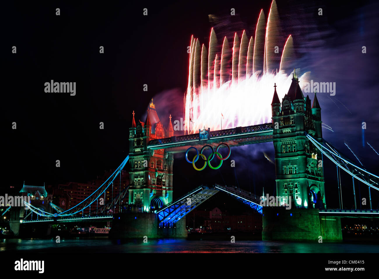 London, England, UK Freitag, 27. Juli 2012 Tower Bridge Feuerwerk Licht auf der Themse, als die Olympische Fackel die letzte Etappe der Reise zum Olympischen Stadion fährt. London, Gastgeber der 30. Olympischen Spiele vorbereitet für die Eröffnungsfeier mit einem Feuerwerk und Licht zeigen auf Tower Bridge, City of London, England, UK Stockfoto
