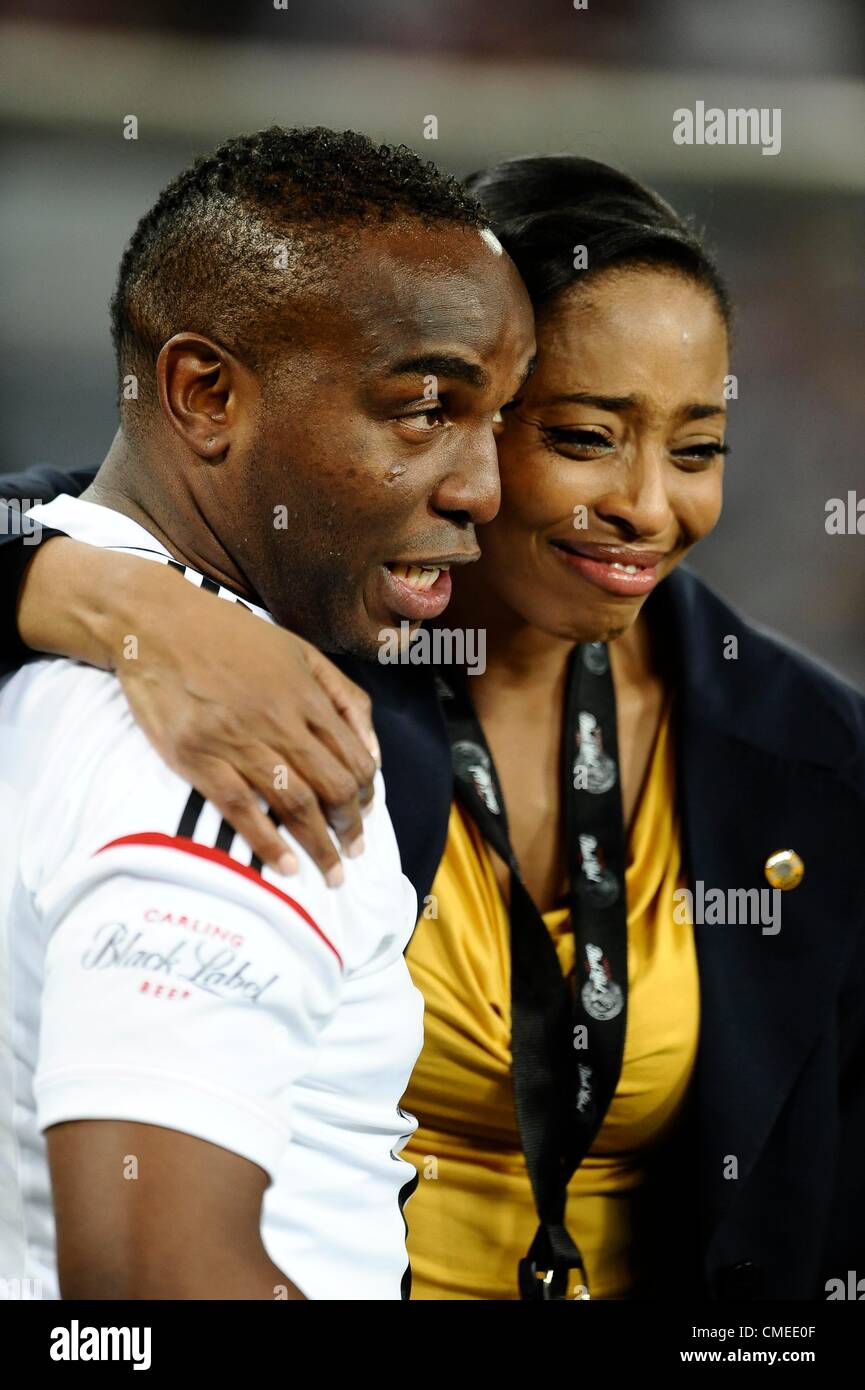 JOHANNESBURG, Südafrika - Juli 28, Benni McCarthy Komfort Chiefs Marketing Manger Jessica Motaung während der Carling Black Label Pokalspiel zwischen Orlando Pirates und Kaizer Chiefs im FNB-Stadion am 28. Juli 2012 in Johannesburg, Südafrika-Foto von Lefty Shivambu / Gallo Images Stockfoto