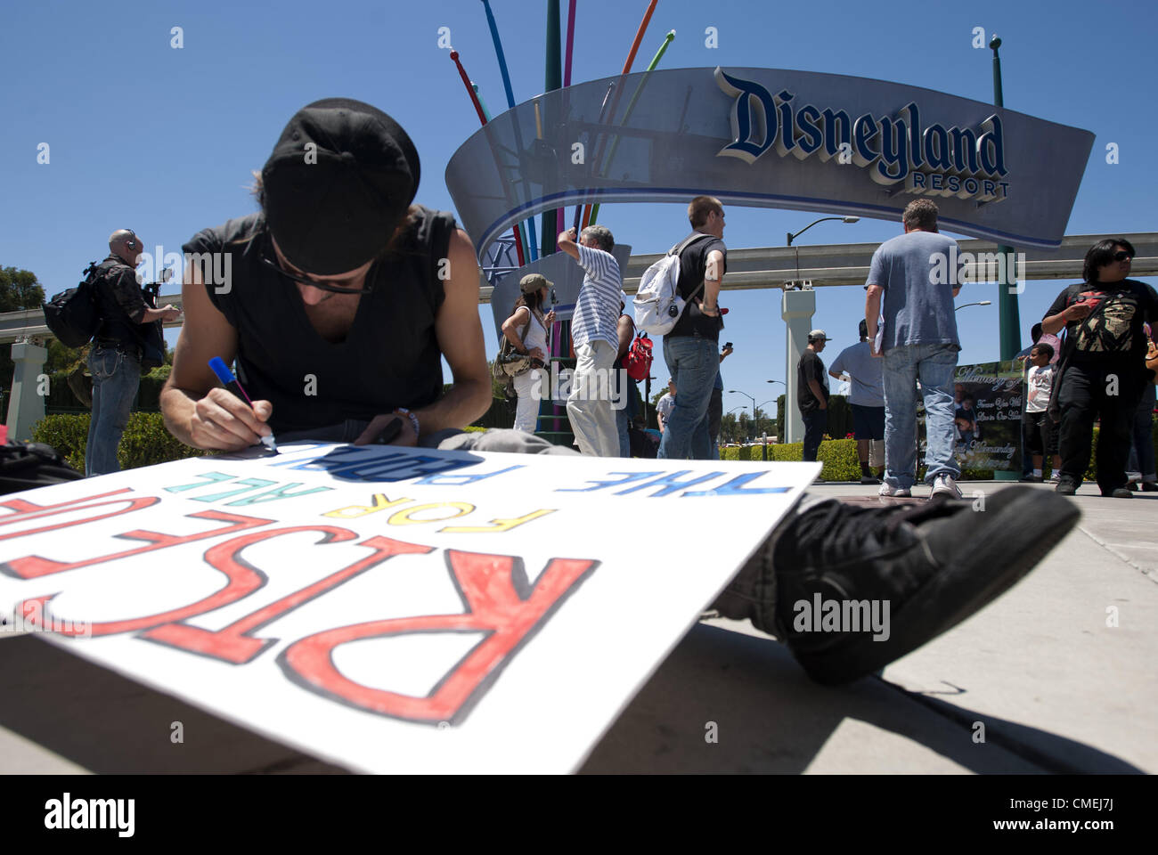 28. Juli 2012 - Anaheim, Kalifornien, USA - A-Demonstrator stellt den letzten Schliff auf einem Schild am Eingang Süd Hafen nach DIsneyland am Samstagnachmittag... ---Mehrere Dutzend Demonstranten erschienen am Eingang zum Disneyland auf South Harbor Blvd. Samstag mit Schilder und Plakate protestieren die jüngsten Dreharbeiten Todesfälle von mehreren jungen Männern in Auseinandersetzungen mit der Polizei von Anaheim, Manuel Diaz, 25 einschließlich beteiligt, die Bewohner sagen war unbewaffnet. (Kredit-Bild: © David Bro/ZUMAPRESS.com) Stockfoto