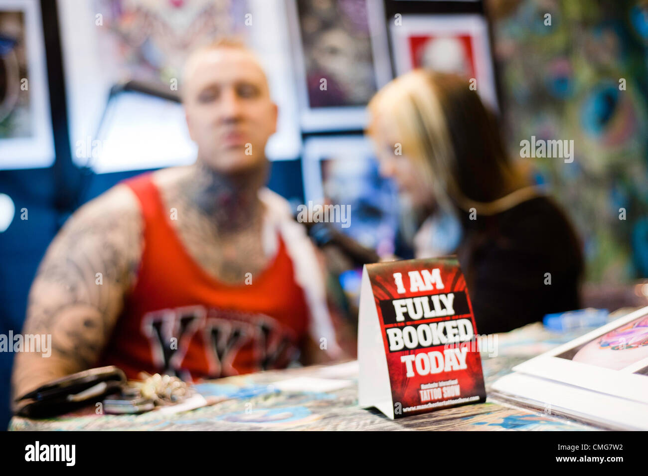 Manchester, UK - 4. August 2012: ein Schild mit der Aufschrift "Ich bin ausgebucht heute" auf dem Tisch von einem Künstler Tattoing Besucher während der Manchester-Tattoo-Show, eine der beliebtesten Konventionen des Vereinigten Königreichs tattoo Gemeinschaft. Stockfoto
