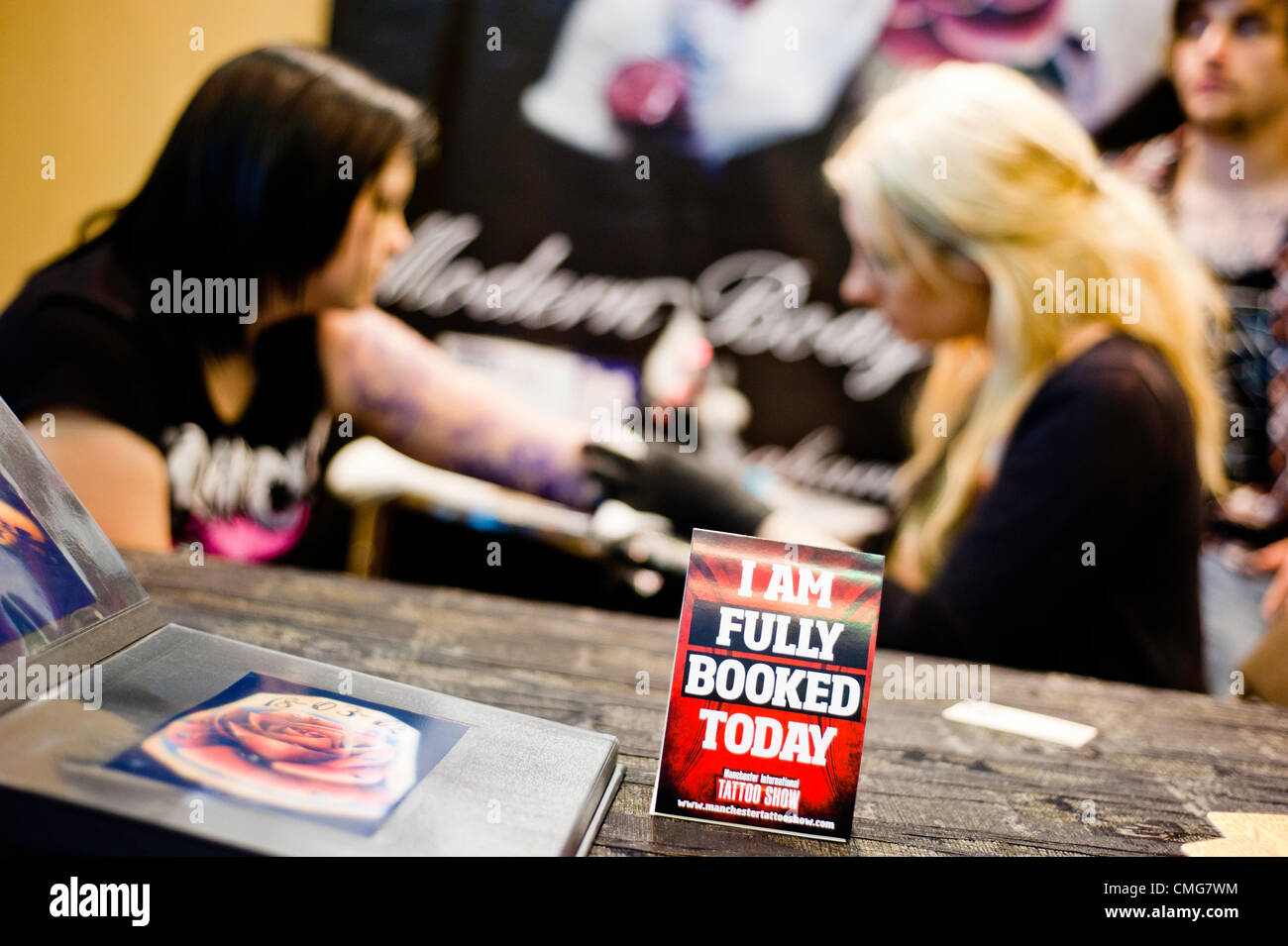 Manchester, UK - 4. August 2012: ein Schild mit der Aufschrift "Ich bin heute ausgebucht" steht auf dem Tisch des Künstlers während der Manchester-Tattoo-Show, eine der beliebtesten Konventionen des Vereinigten Königreichs tattoo Gemeinschaft. Stockfoto